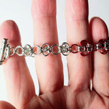 close up of chainmaille bracelet with red links
