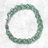 Helm weave Chainmaille bracelet with green and silver links on a white background