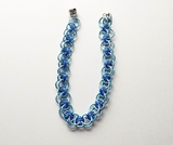 Blue helm chainmaille bracelet on a white background