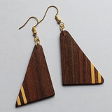 Wooden triangle earrings with basswood accents on a light gray background